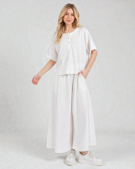 Woman wearing a white outfit on a plain background