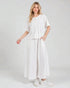 Woman wearing a white outfit on a plain background