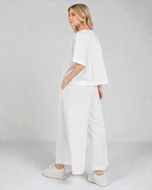 Woman wearing a white outfit on a plain background