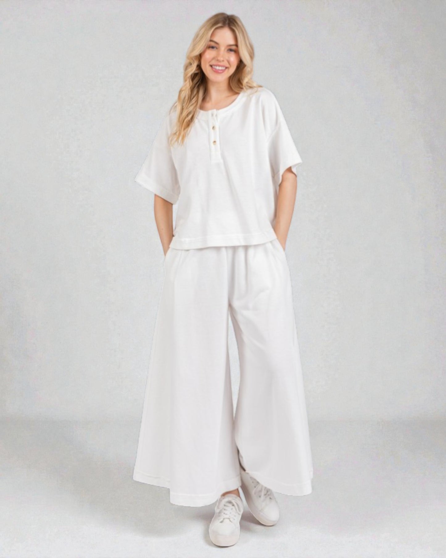 Woman wearing a white outfit on a plain background