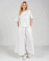 Woman wearing a white outfit on a plain background