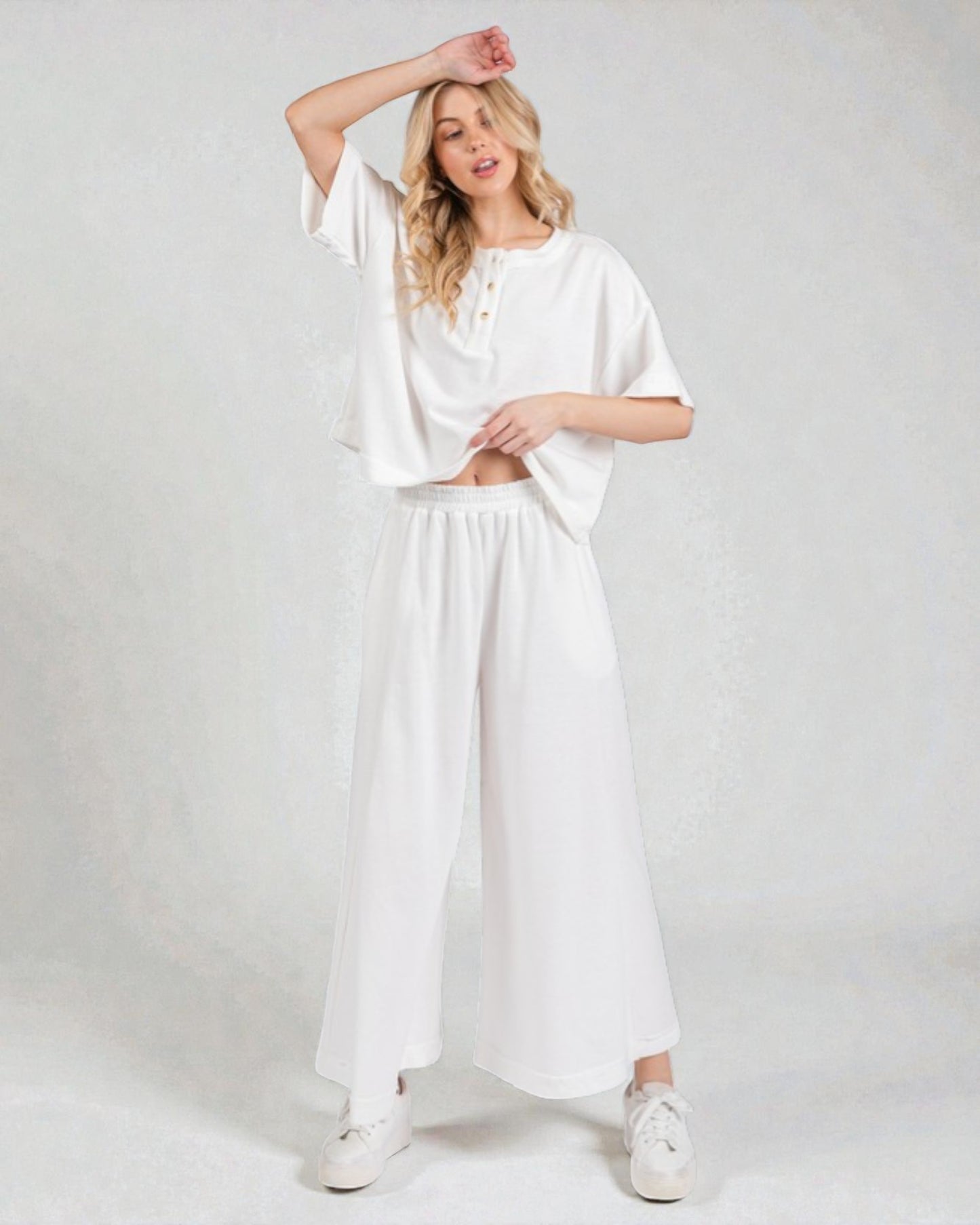 Woman wearing a white outfit on a plain background