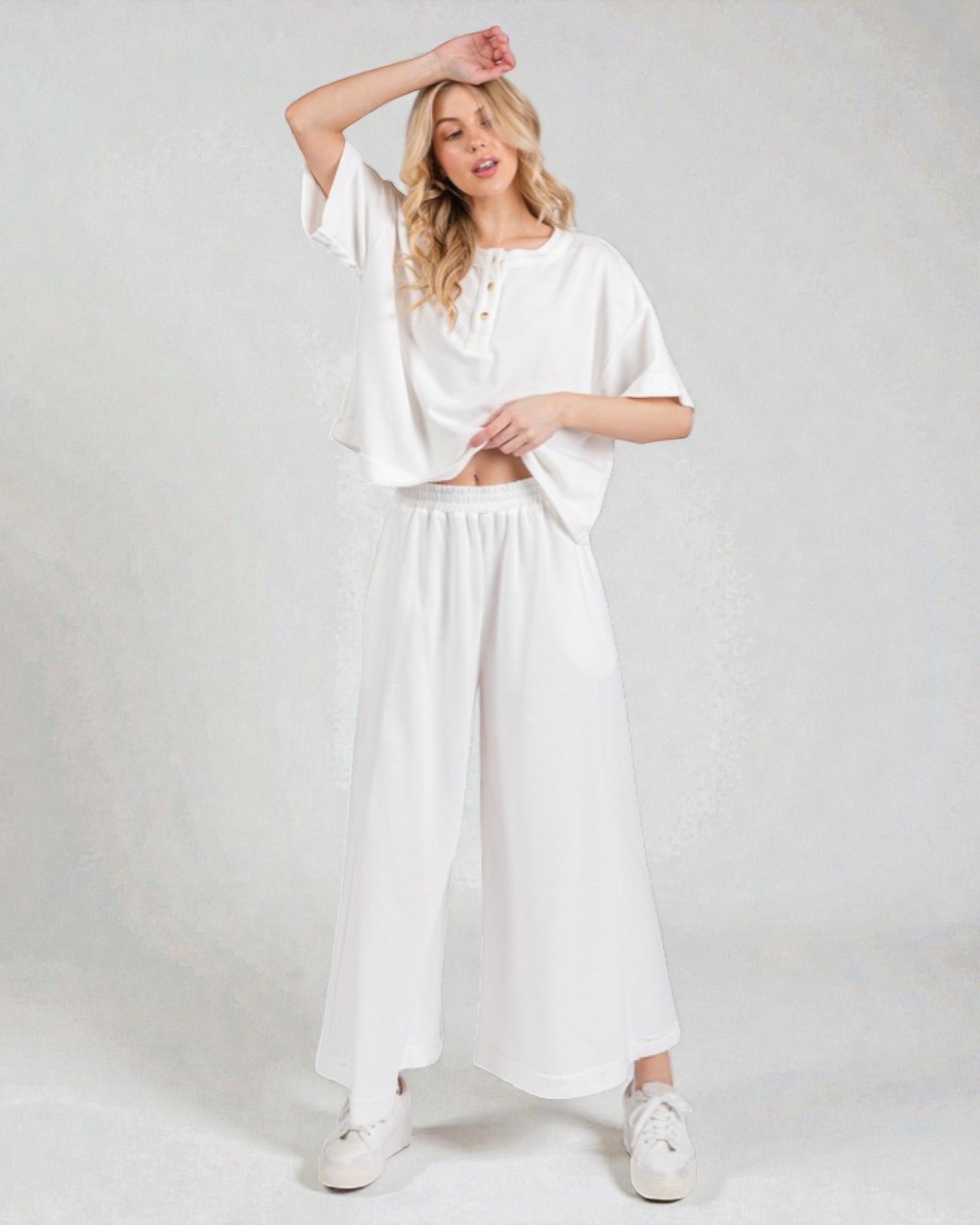 Woman wearing a white outfit on a plain background