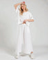 Woman wearing a white outfit on a plain background