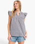 A woman wearing a black and white gingham check sleeveless blouse with ruffled cap sleeves and a smocked neckline, paired with denim shorts, against a plain white background.