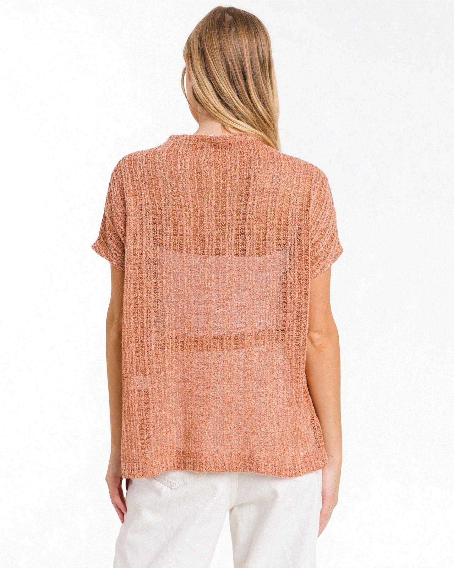 Woman wearing a sleeveless orange top on a white background