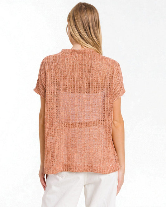 Woman wearing a sleeveless orange top on a white background