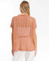Woman wearing a sleeveless orange top on a white background