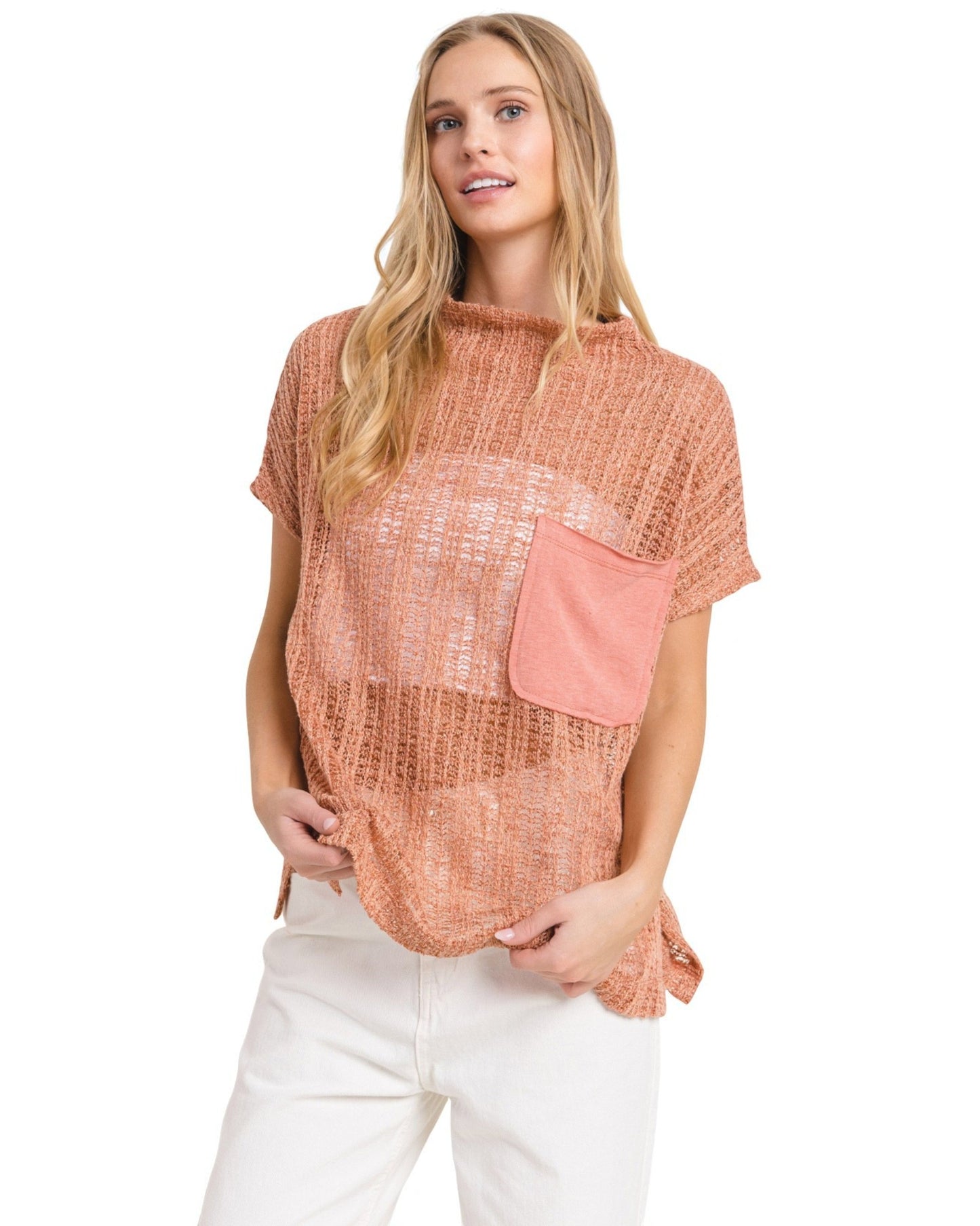 Woman wearing a pink textured top with a pocket on a white background