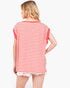 A woman shown from the back wearing a red and white horizontally striped short-sleeve top with frayed white shorts, against a plain light gray studio background.