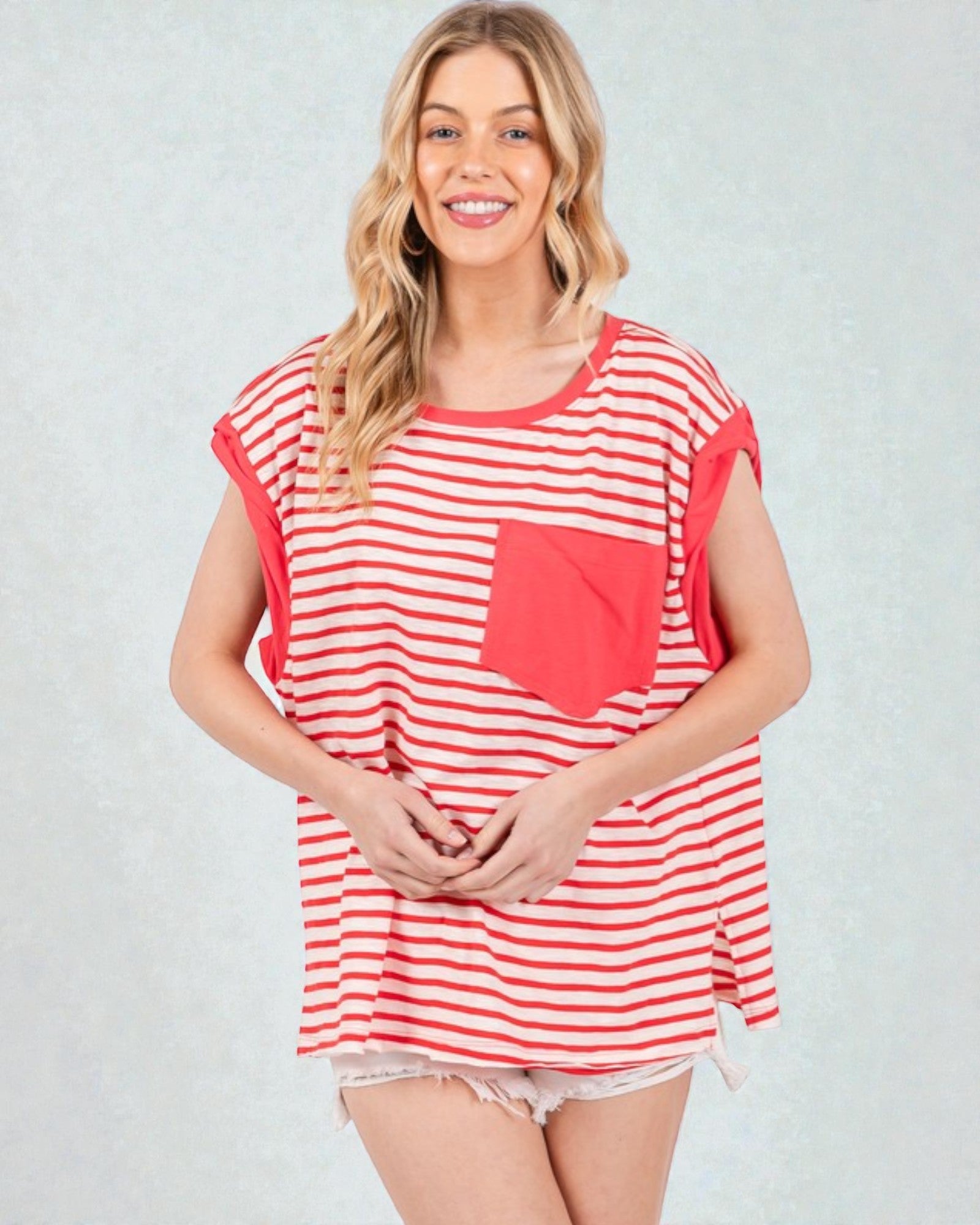 Woman wearing a red and white striped tunic with a pocket on a light gray background