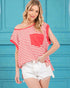 Woman wearing a red and white striped top with a pocket against a blue background