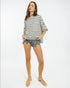 Woman wearing a striped shirt and denim shorts on a white background