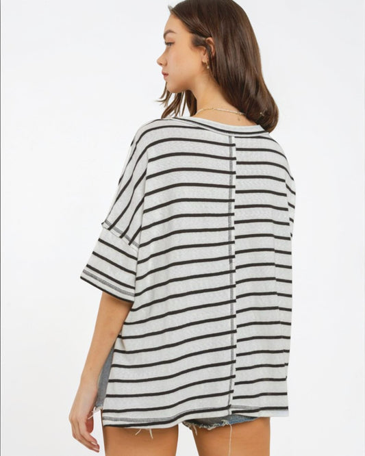 Woman wearing a black and white striped shirt on a plain background