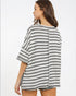 Woman wearing a black and white striped shirt on a plain background