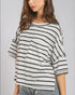 Woman wearing a striped shirt with a pocket on a plain background