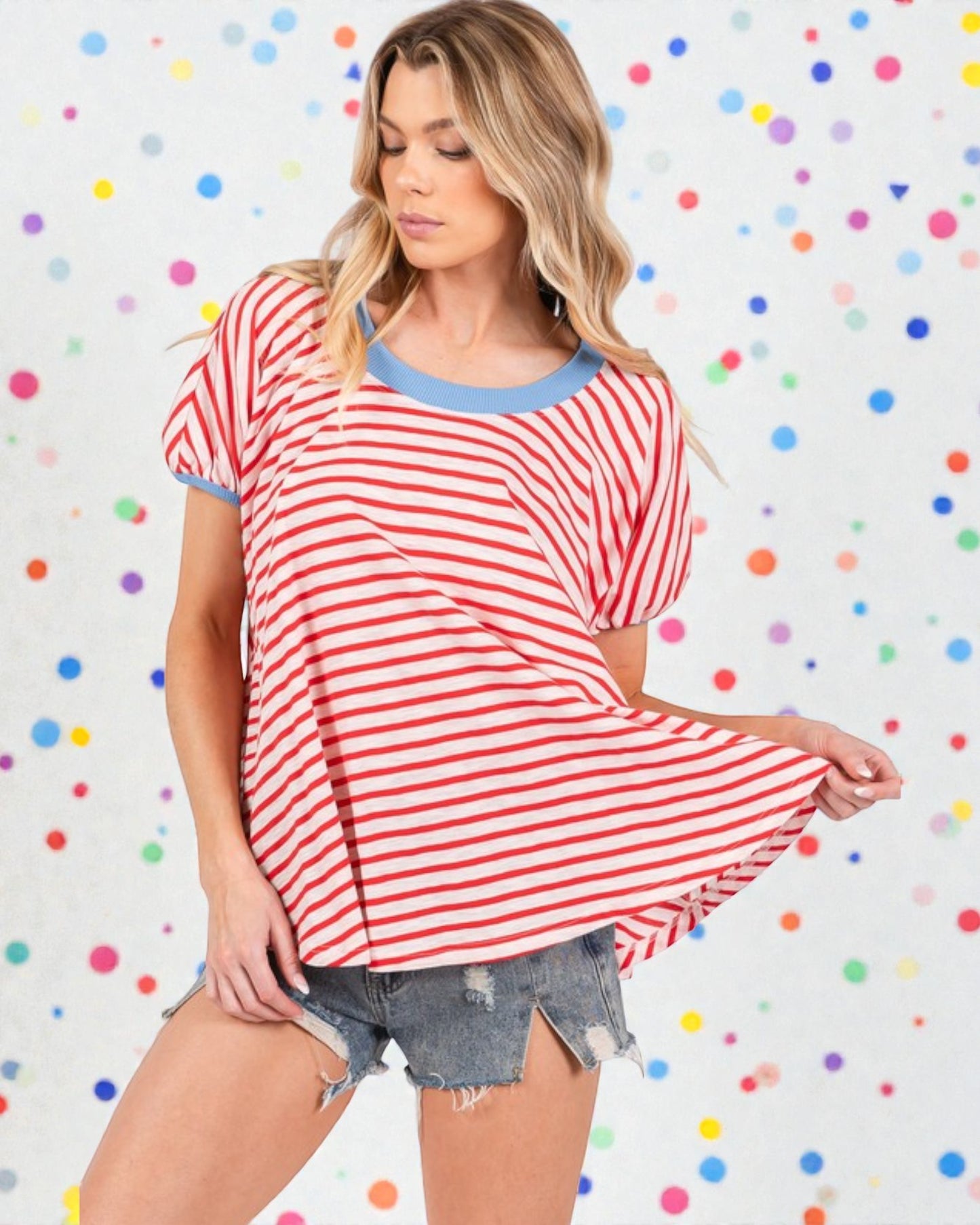 Woman wearing a red and white striped shirt with denim shorts on a polka dot background