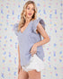 Woman wearing a blue and white striped top with a colorful abstract pattern in the background