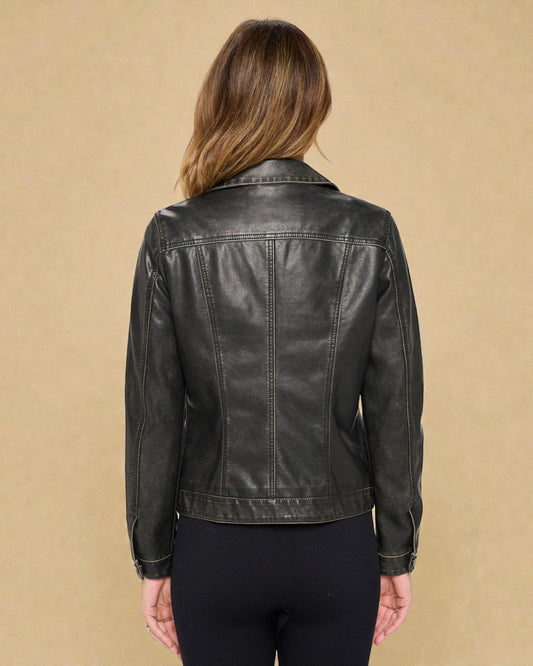 Person wearing a black leather jacket on a beige background