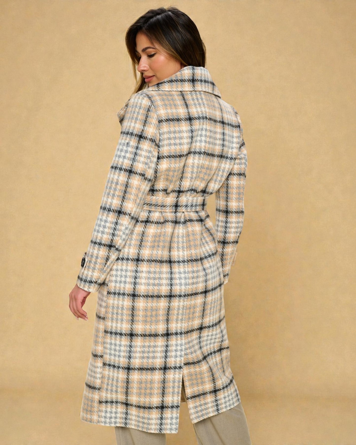Woman wearing a plaid coat against a beige background