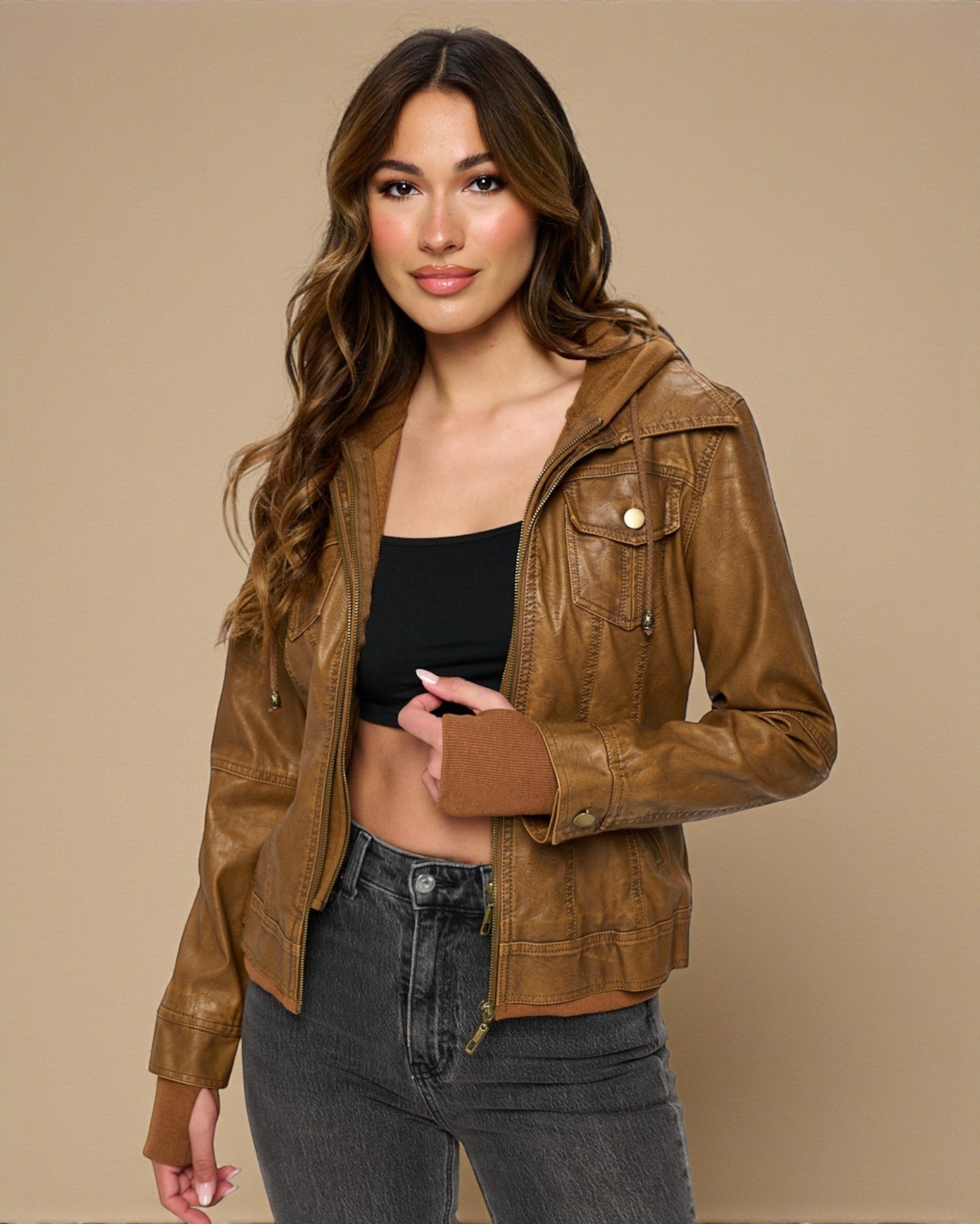 Woman wearing a brown leather jacket on a beige background