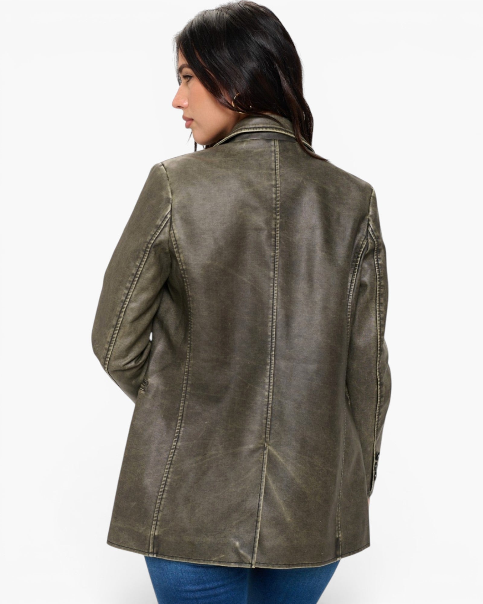 A woman shown from the back wearing an olive green faux leather jacket, paired with blue jeans, against a plain white background.
