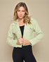 Woman wearing a light green jacket against a beige background