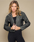 Woman wearing a black leather jacket against a beige background
