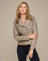 Woman wearing a beige jacket against a plain background