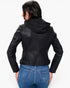 A woman shown from the back wearing a black faux-leather hooded moto jacket and blue jeans against a plain white background.