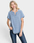 Woman wearing a blue striped shirt and jeans on a white background