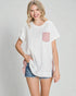 Woman wearing a white t-shirt with a pink pocket design on a plain background