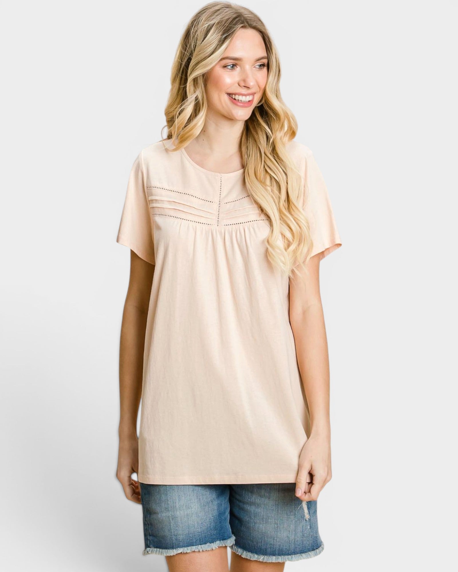 Camiseta de manga corta con cuello redondo y detalle de ojales en color melocotón