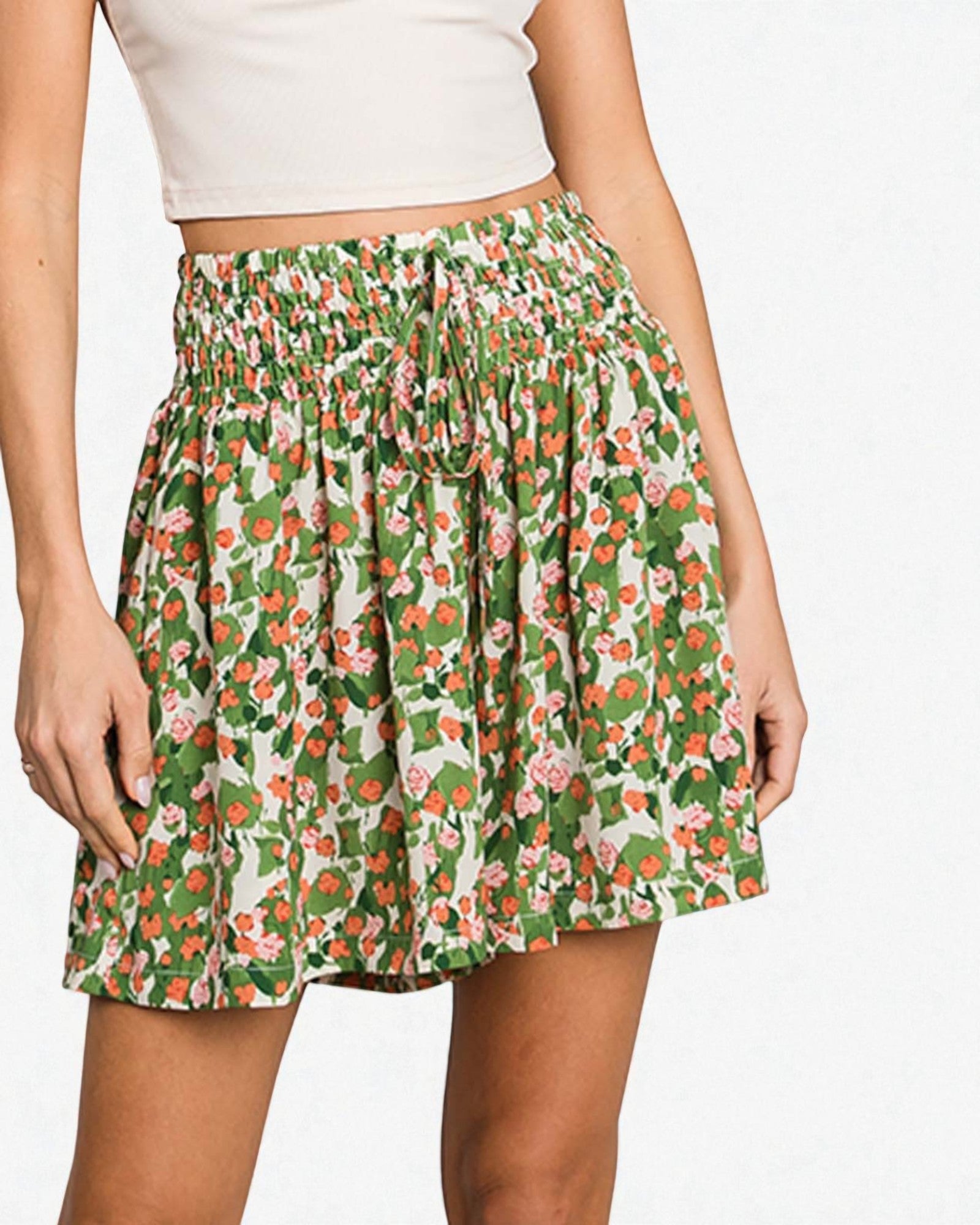 Person wearing a green floral skirt on a white background