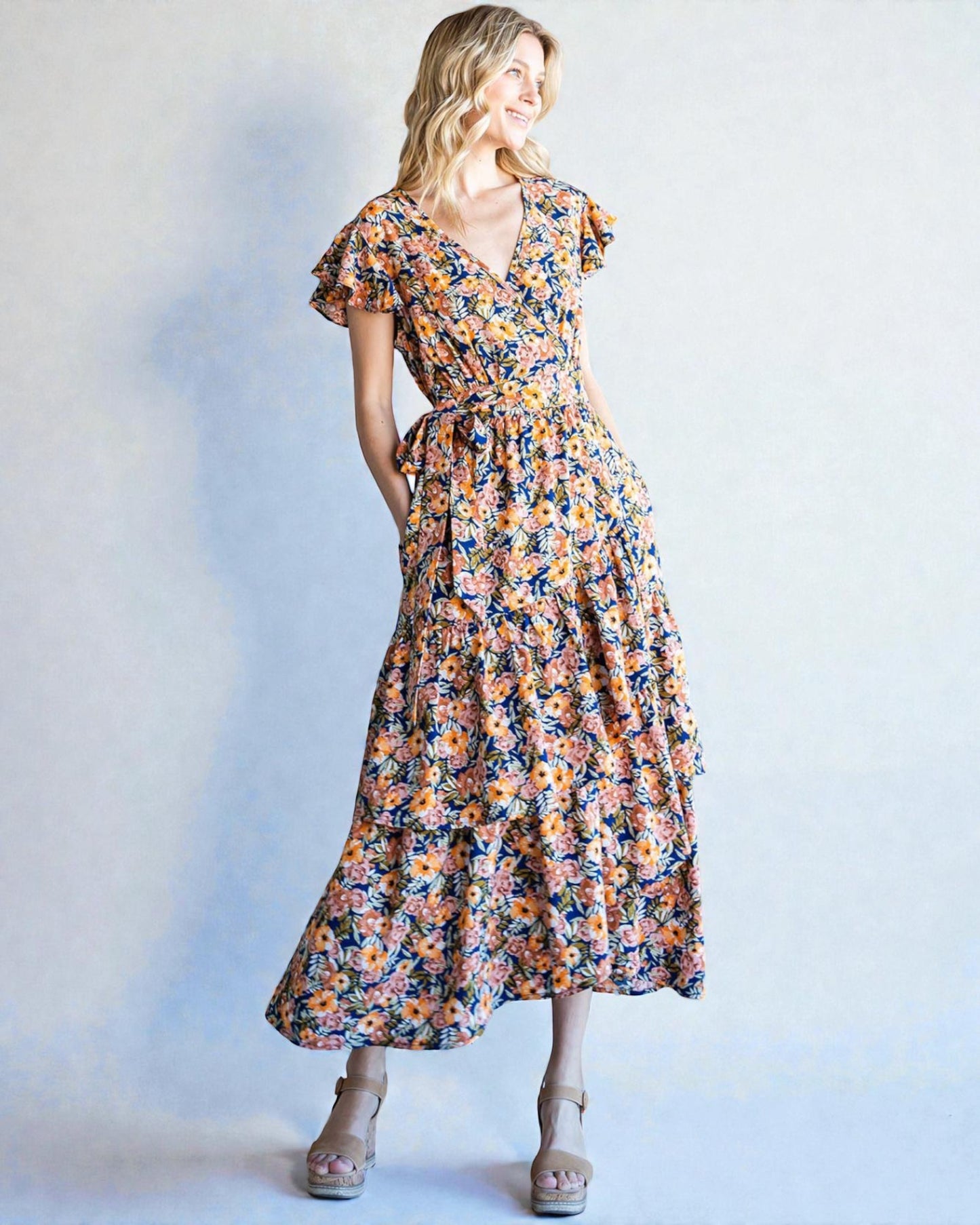 Woman wearing a floral dress against a plain background