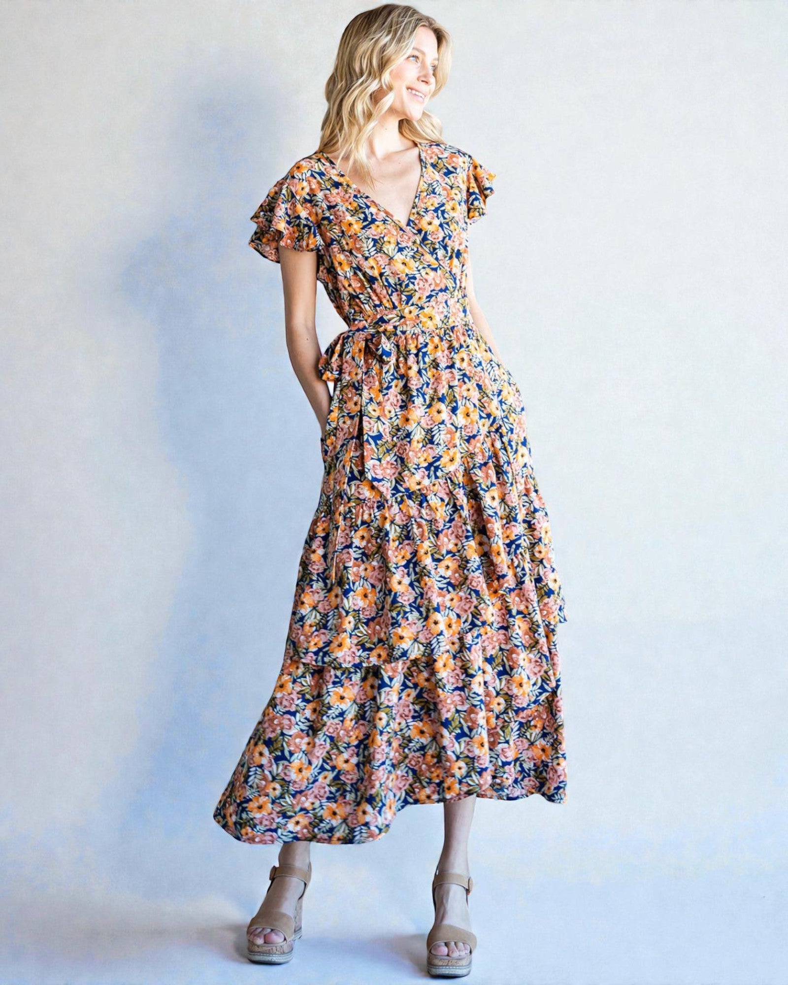 Woman wearing a floral dress against a plain background