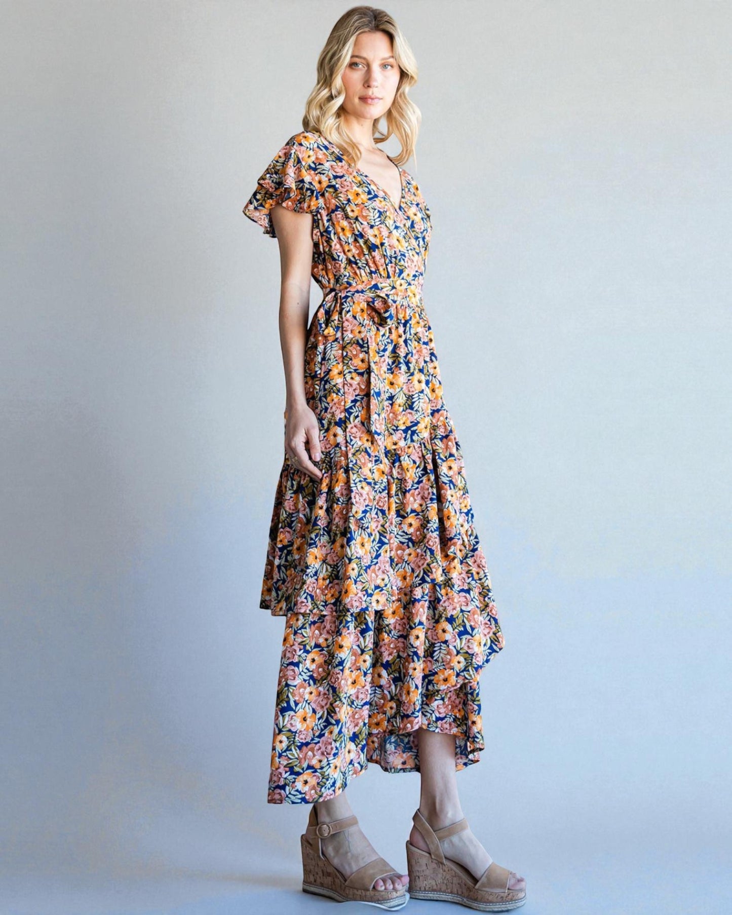 Woman wearing a floral dress against a plain background