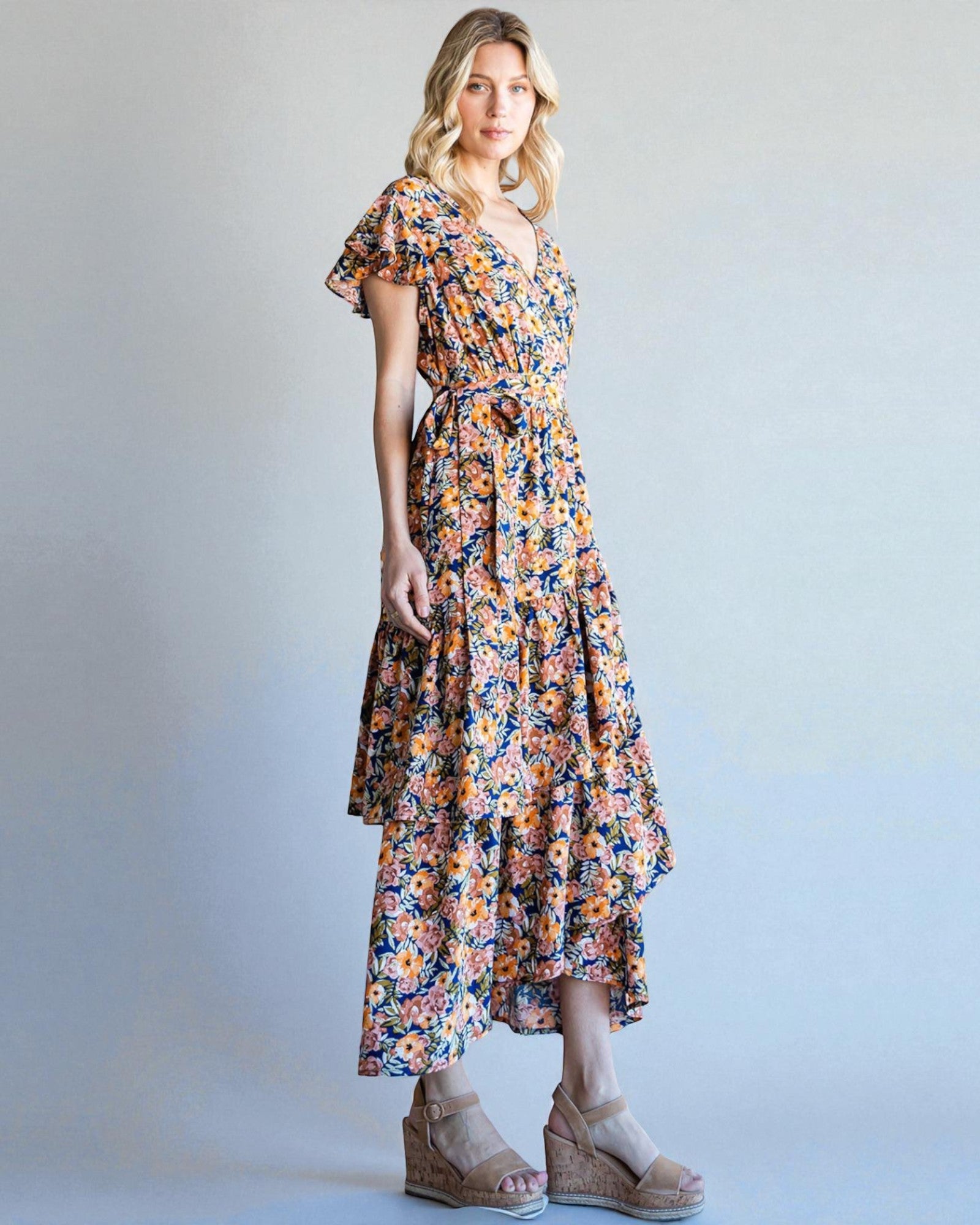 Woman wearing a floral dress against a plain background