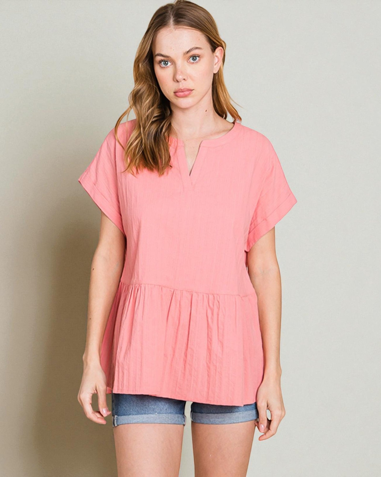 Woman wearing a pink blouse with a plain background