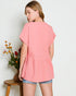 Woman wearing a pink top with a plain background