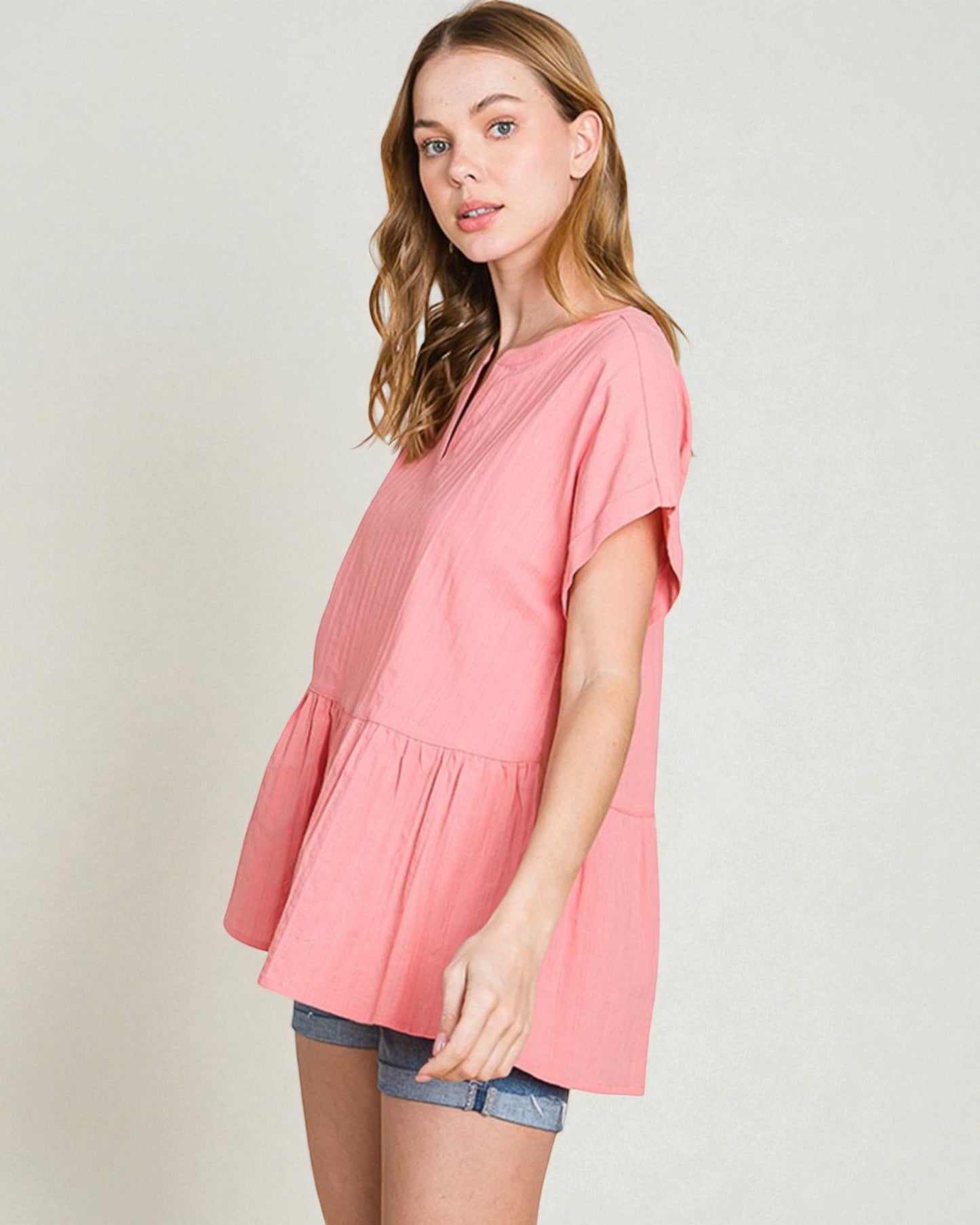 Woman wearing a pink blouse with a plain background