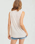 Woman wearing a sleeveless striped top and denim shorts on a plain background