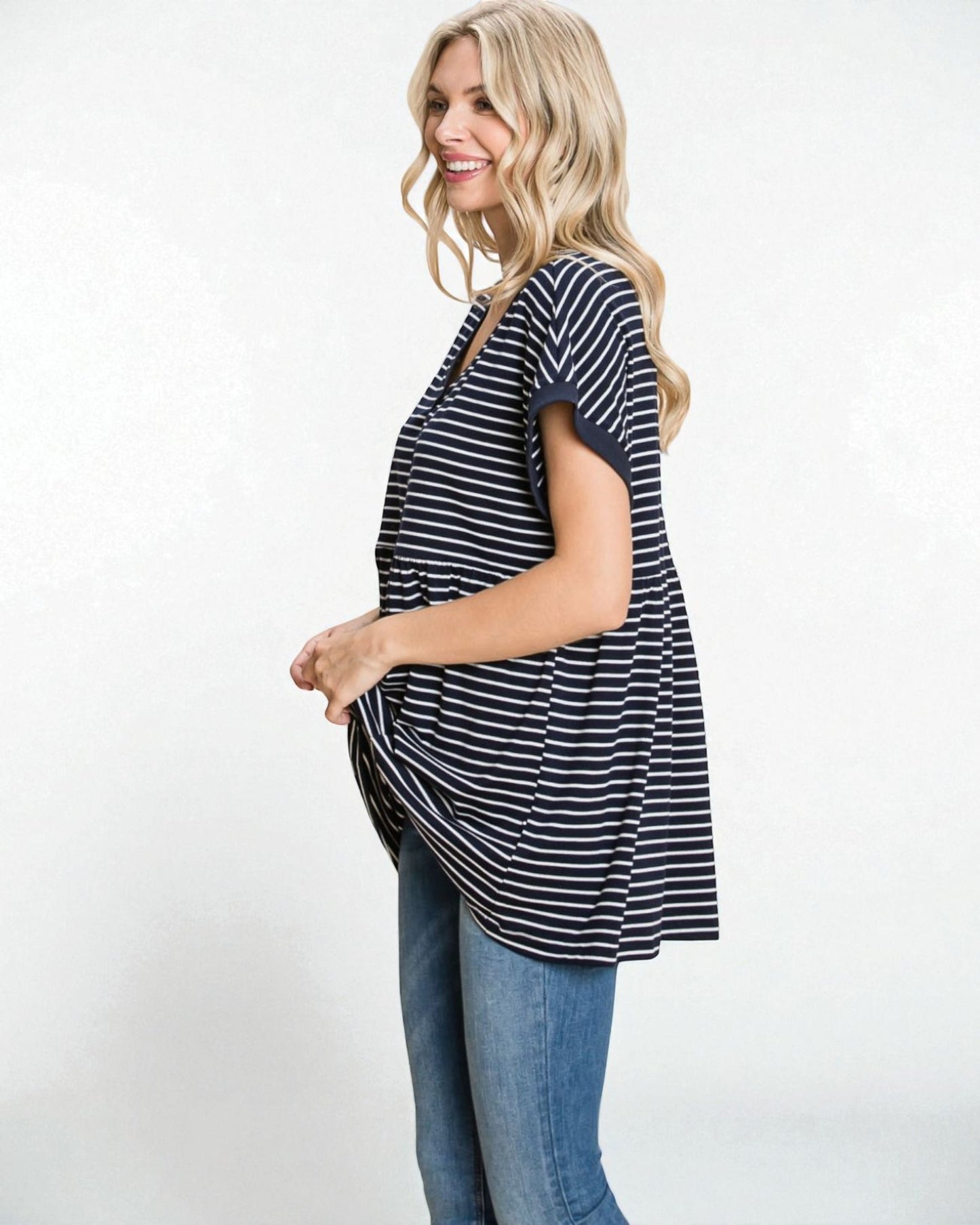 Woman wearing a black and white striped shirt and blue jeans on a white background