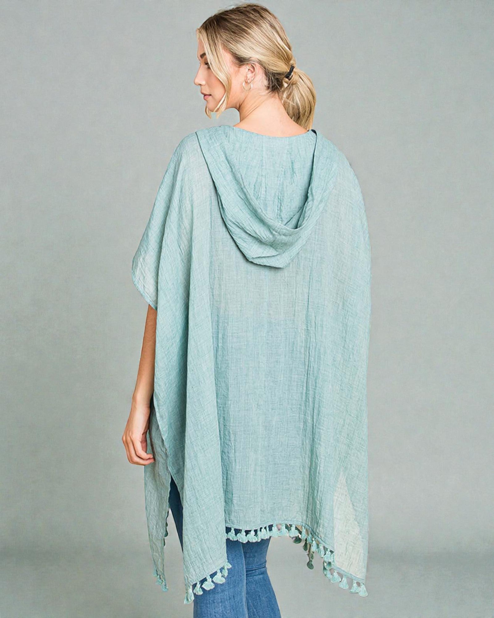 Woman wearing a light blue scarf with a gray background