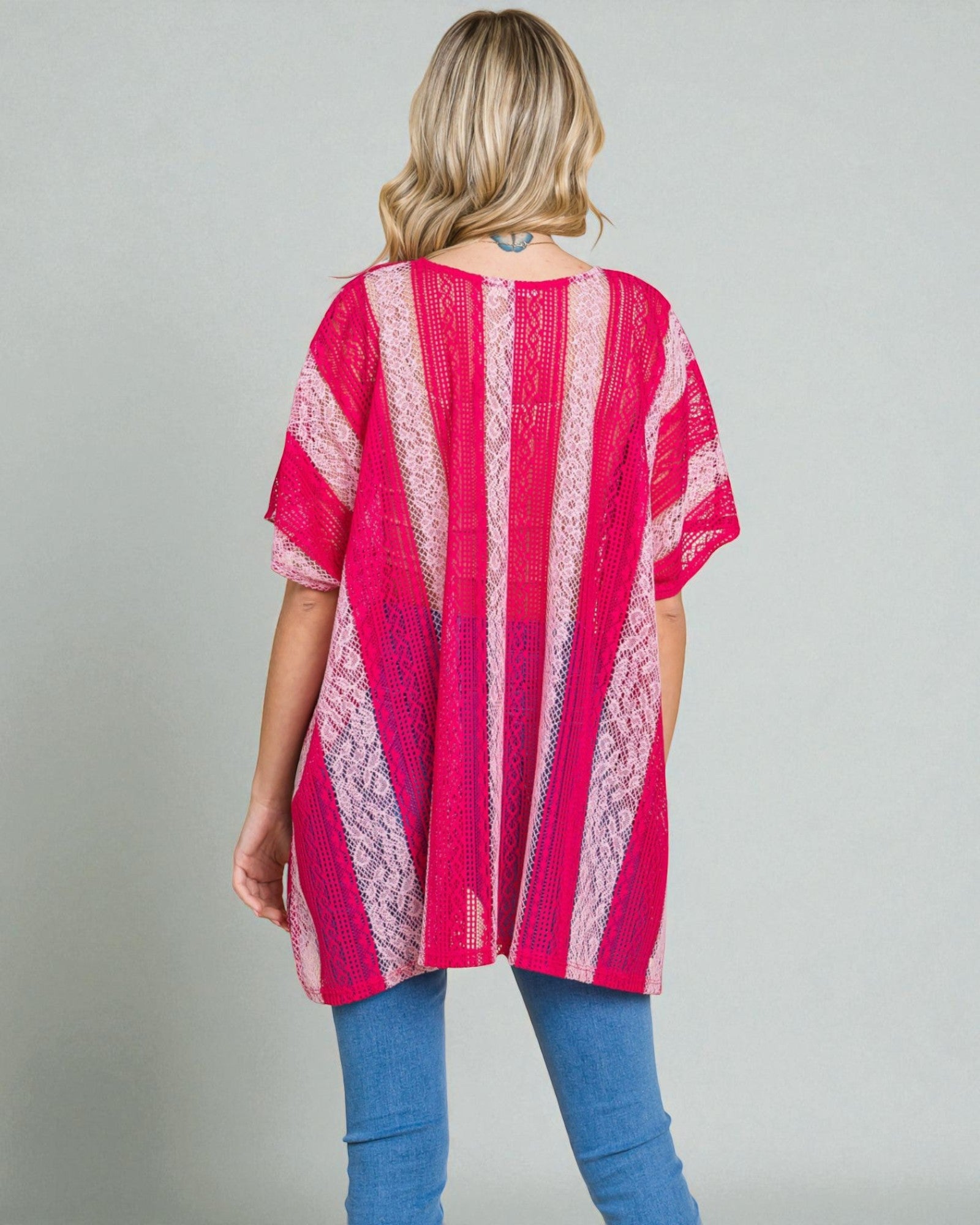 Woman wearing a pink and white striped kimono against a gray background