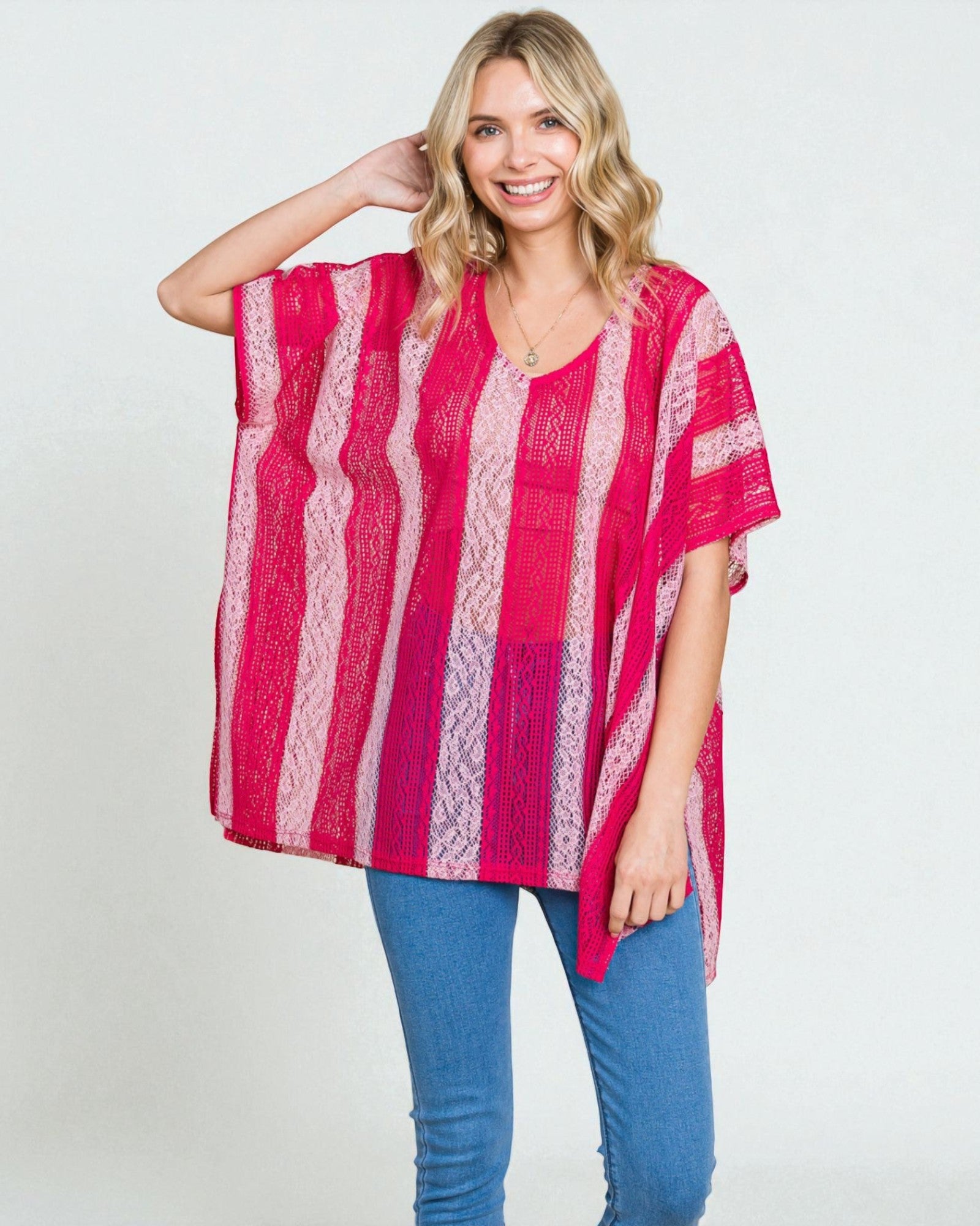 Woman wearing a pink and red striped top with blue jeans on a white background