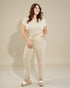 Woman wearing a beige outfit with a plain background