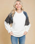 Woman wearing a white and gray sweater with blue jeans on a beige background