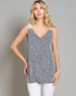 Woman wearing a gray tank top with white trim on a plain background