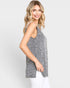 Woman wearing a sleeveless gray top against a white background